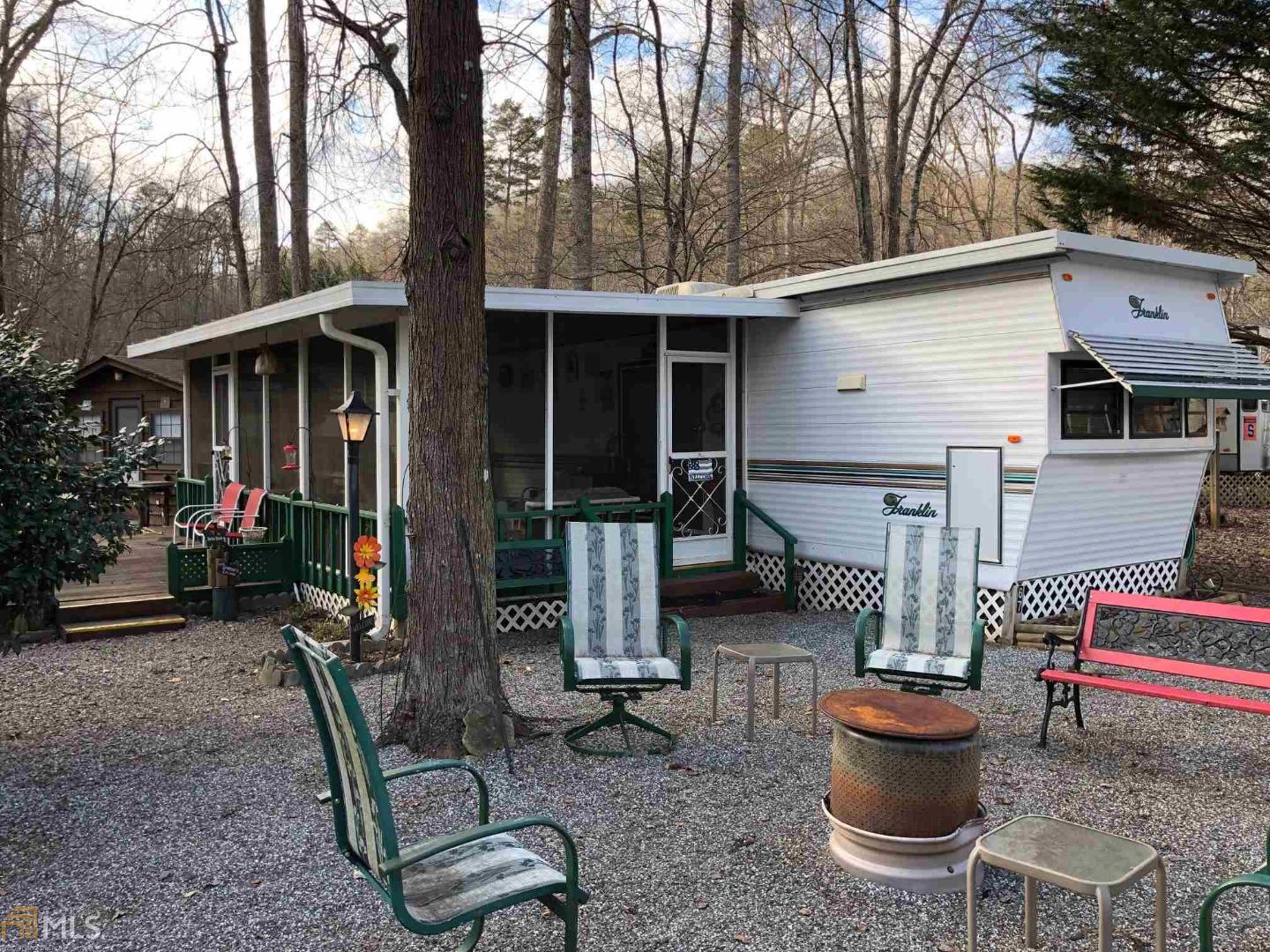 a view of a patio with table and chairs potted plants and a large tree