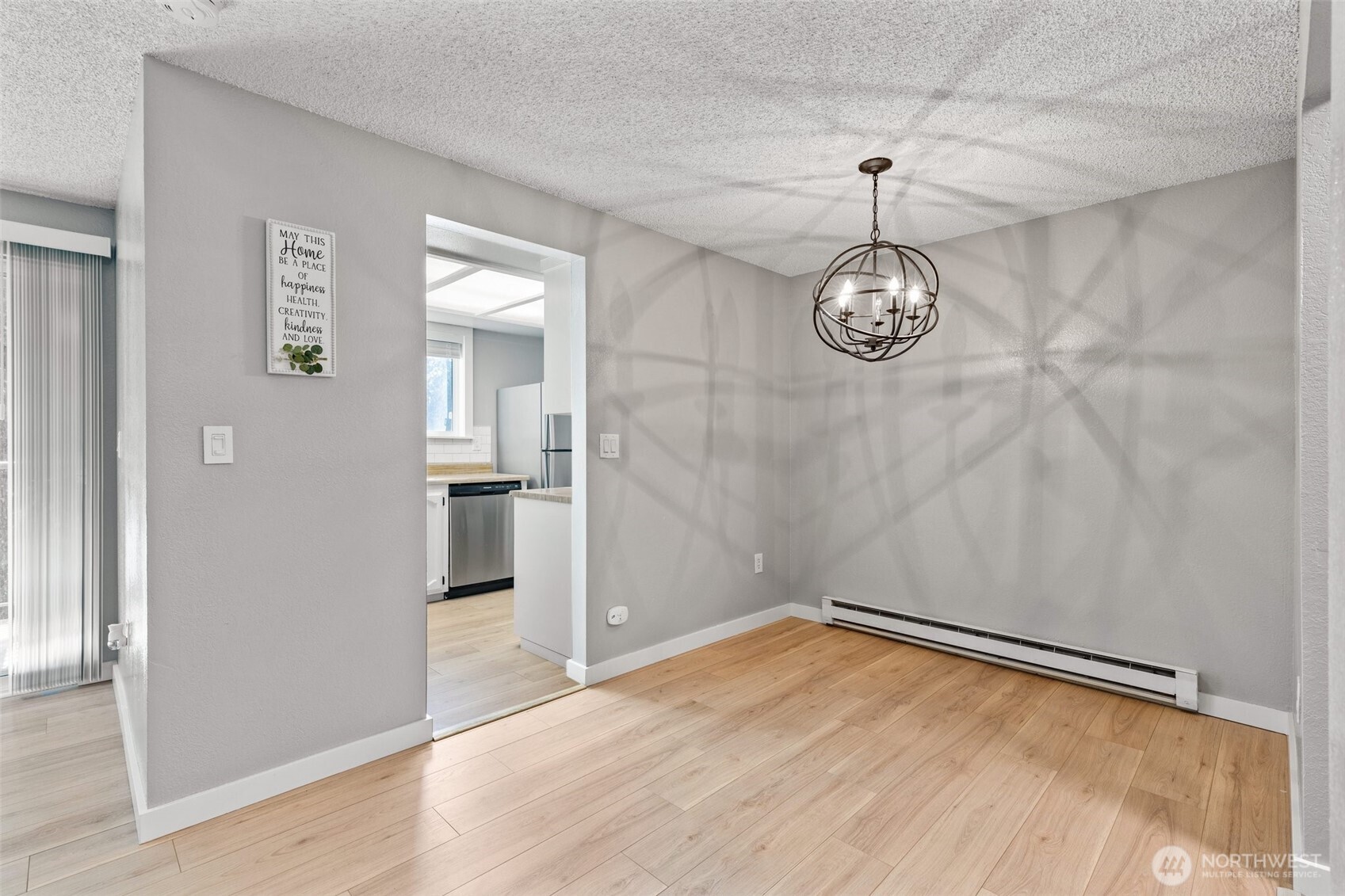820 Cady Road, Unit H203 Everett, WA 98203 - Photo 10 of 30 an empty room with wooden floor and kitchen view