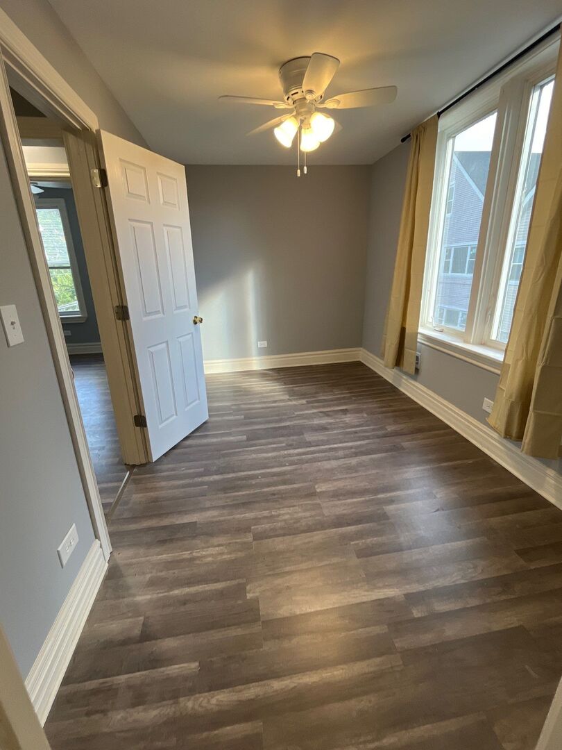 7438 South Champlain Avenue Chicago, IL 60619 - Photo 21 of 33 wooden floor in an empty room with a window