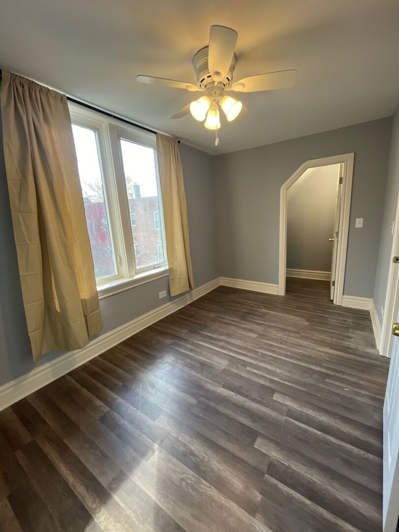 7438 South Champlain Avenue Chicago, IL 60619 - Photo 23 of 33 wooden floor in an empty room with a window