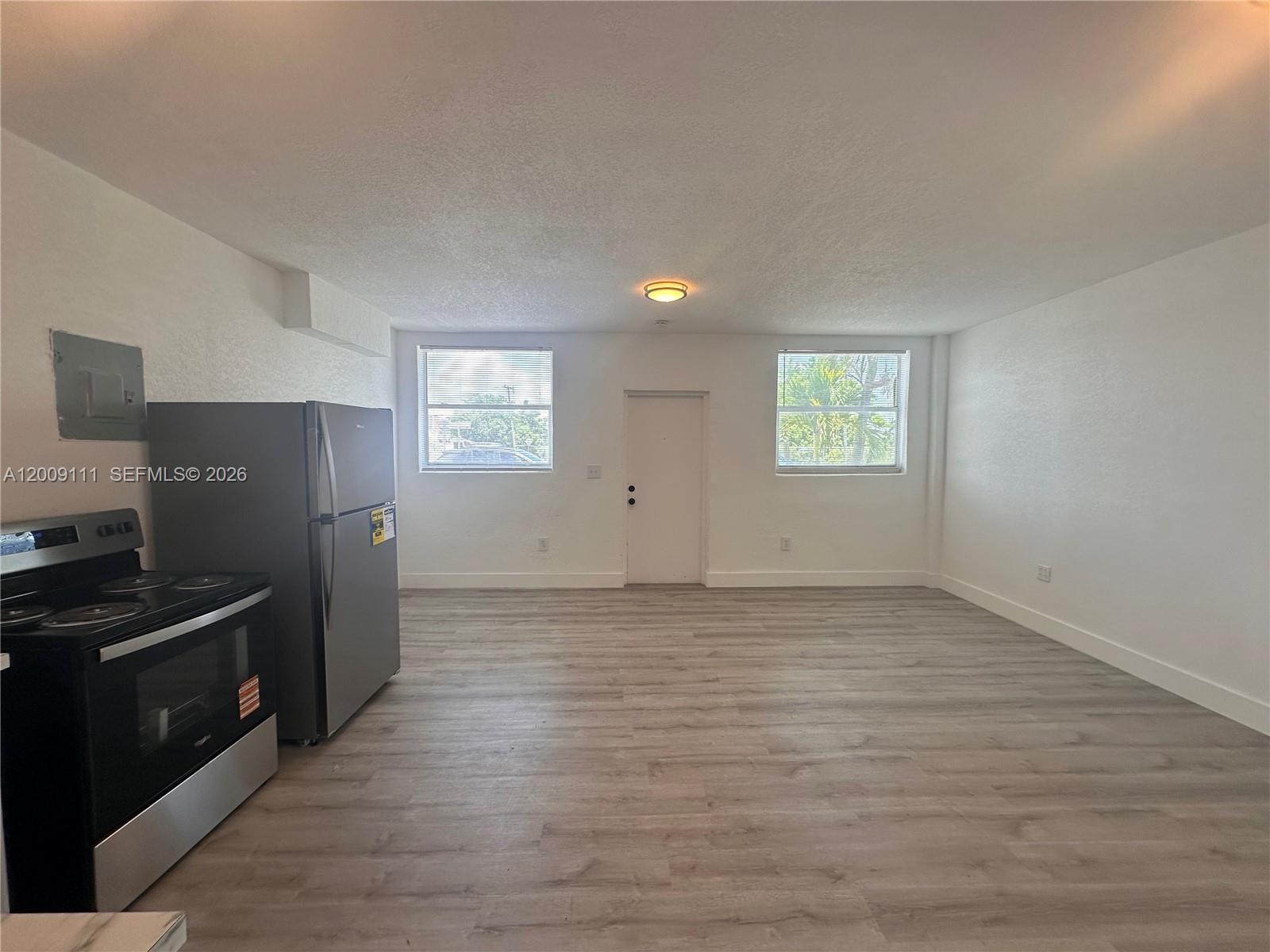 50 Northwest 79th Street, Unit 6 Miami, FL 33150 - Photo 1 of 30 a view of a kitchen with an empty room and wooden floor