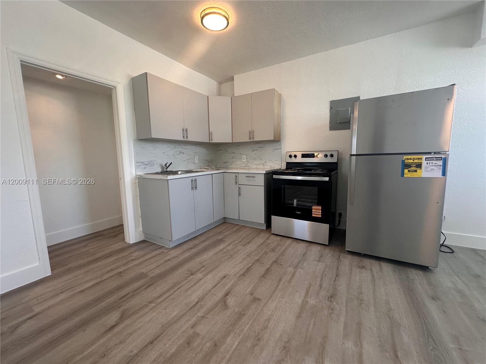 50 Northwest 79th Street, Unit 6 Miami, FL 33150 - Photo 12 of 30 a kitchen with stainless steel appliances granite countertop a refrigerator and a stove top oven