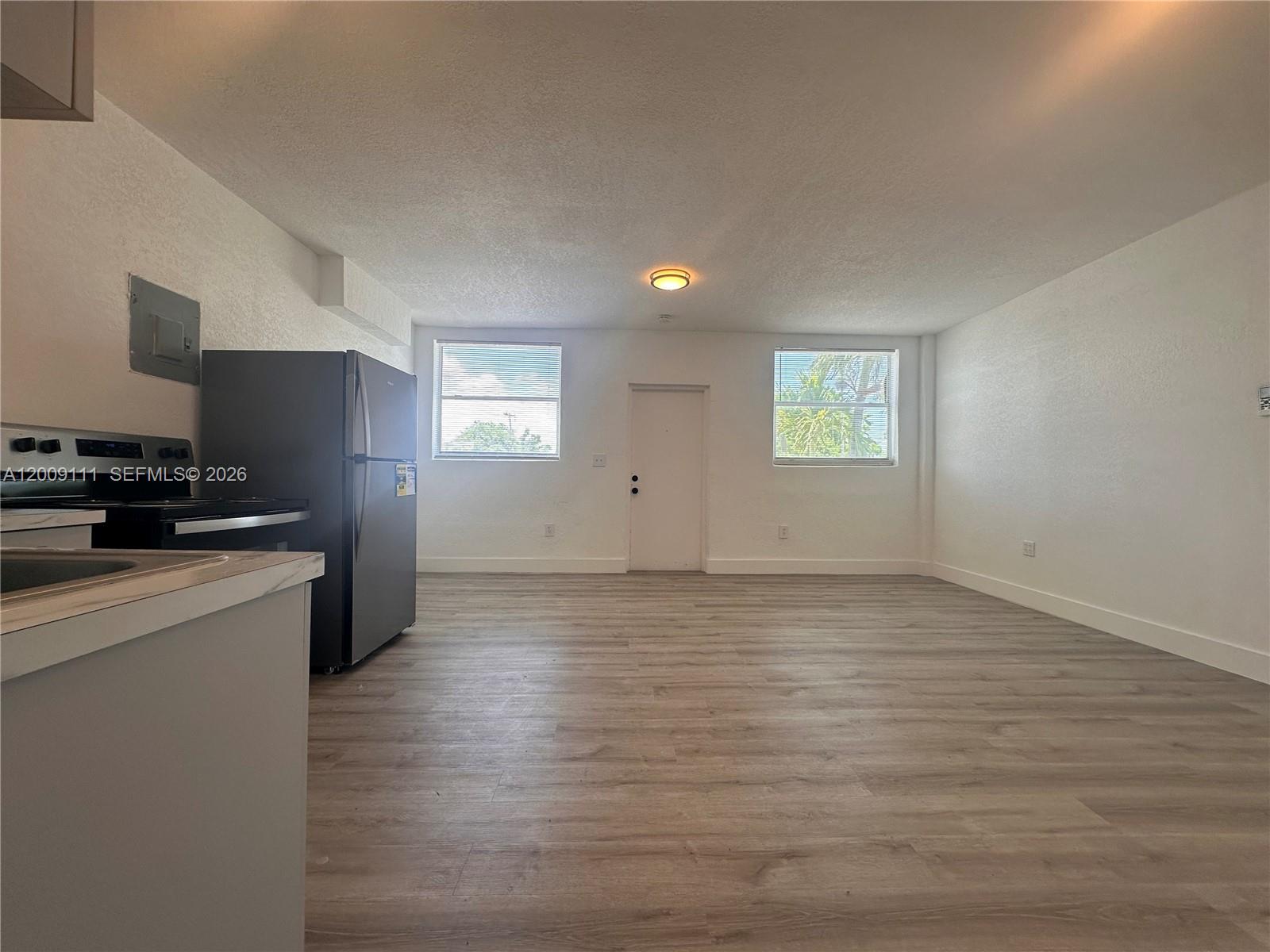 50 Northwest 79th Street, Unit 6 Miami, FL 33150 - Photo 17 of 30 a view of a kitchen with wooden floor and electronic appliances