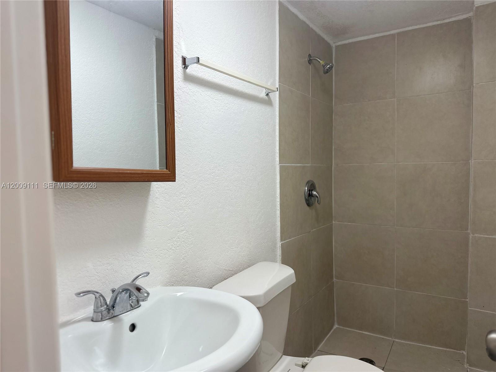 50 Northwest 79th Street, Unit 6 Miami, FL 33150 - Photo 20 of 30 a bathroom with a sink a mirror and a toilet