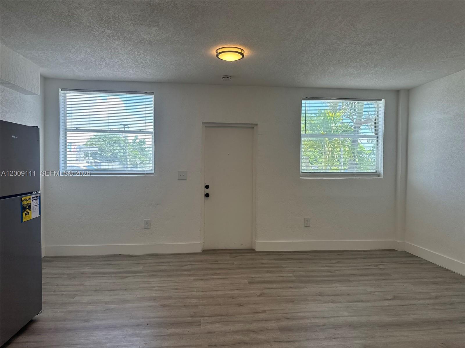 50 Northwest 79th Street, Unit 6 Miami, FL 33150 - Photo 23 of 30 wooden floor in an empty room with a window
