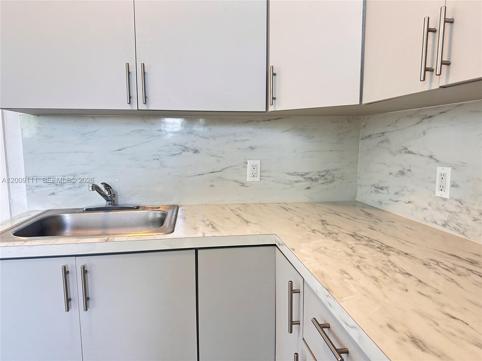 50 Northwest 79th Street, Unit 6 Miami, FL 33150 - Photo 27 of 30 a kitchen with a sink cabinets and washer