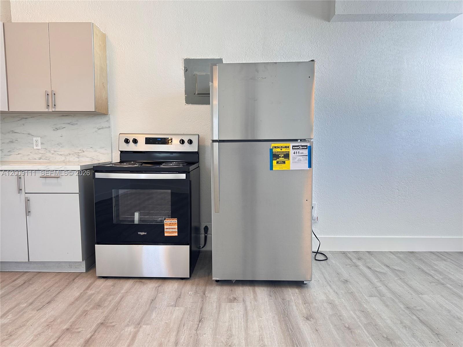 50 Northwest 79th Street, Unit 6 Miami, FL 33150 - Photo 30 of 30 a kitchen with stainless steel appliances granite countertop a refrigerator and a stove top oven