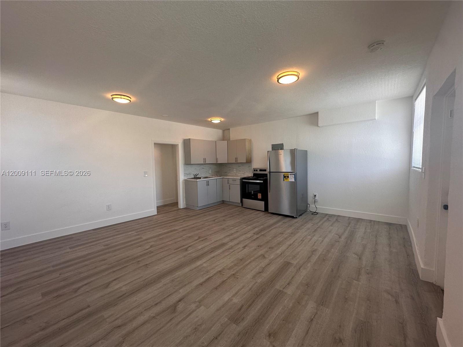 50 Northwest 79th Street, Unit 6 Miami, FL 33150 - Photo 6 of 30 wooden floor in an empty room with a kitchen