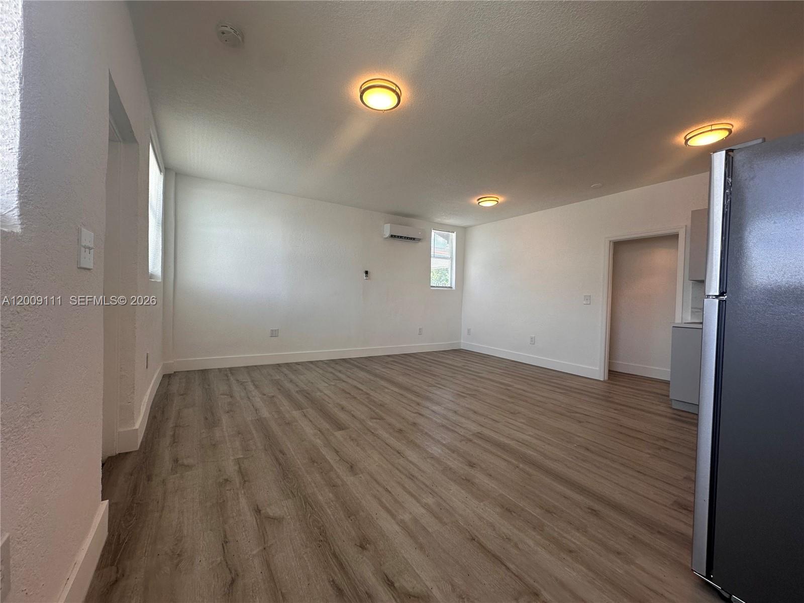 50 Northwest 79th Street, Unit 6 Miami, FL 33150 - Photo 8 of 30 an empty room with wooden floor and windows