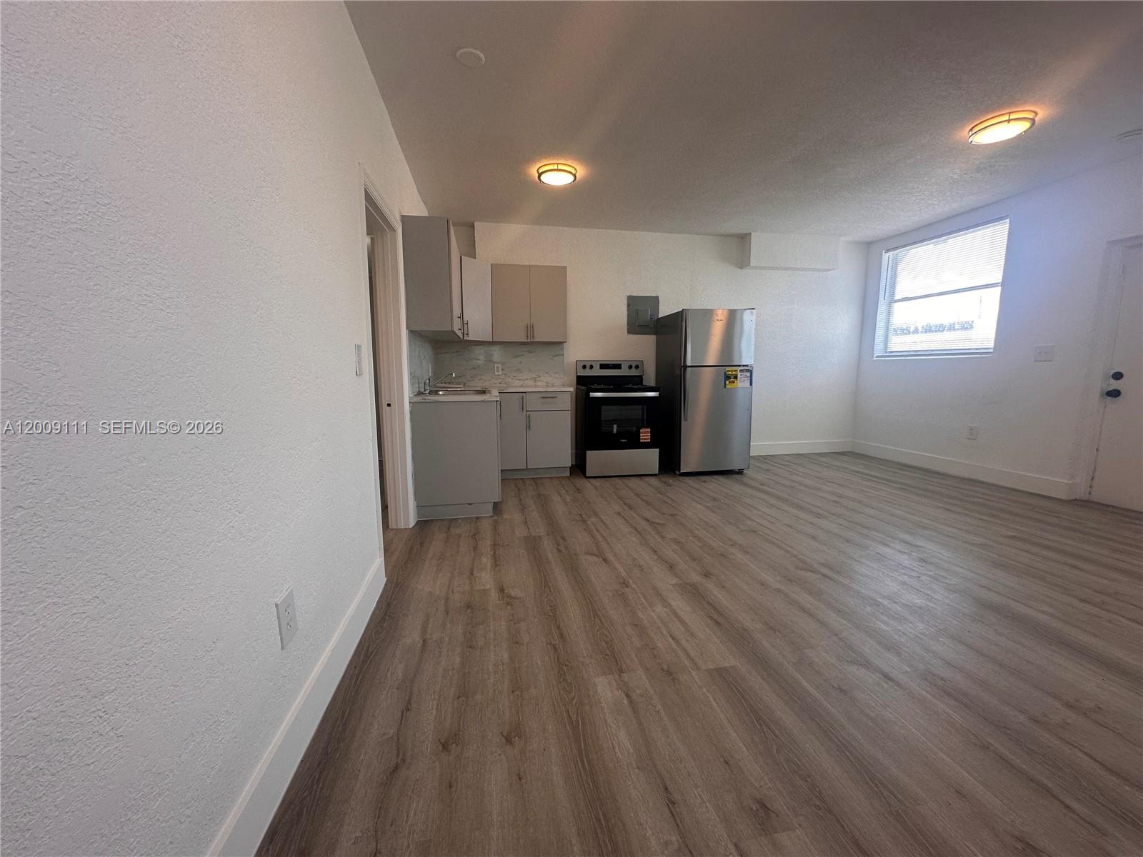 50 Northwest 79th Street, Unit 6 Miami, FL 33150 - Photo 10 of 30 a view of kitchen with furniture and wooden floor