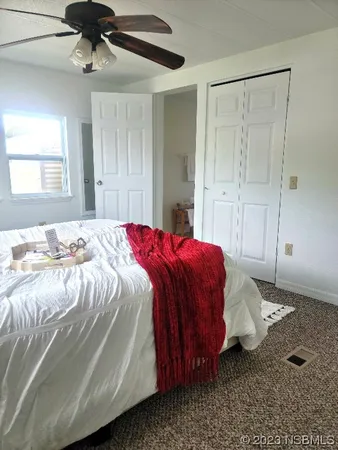 a bed sitting in a bedroom next to a window and a chandelier