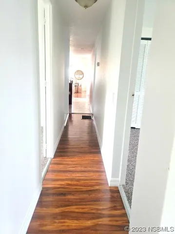 a view of a hallway with wooden floor