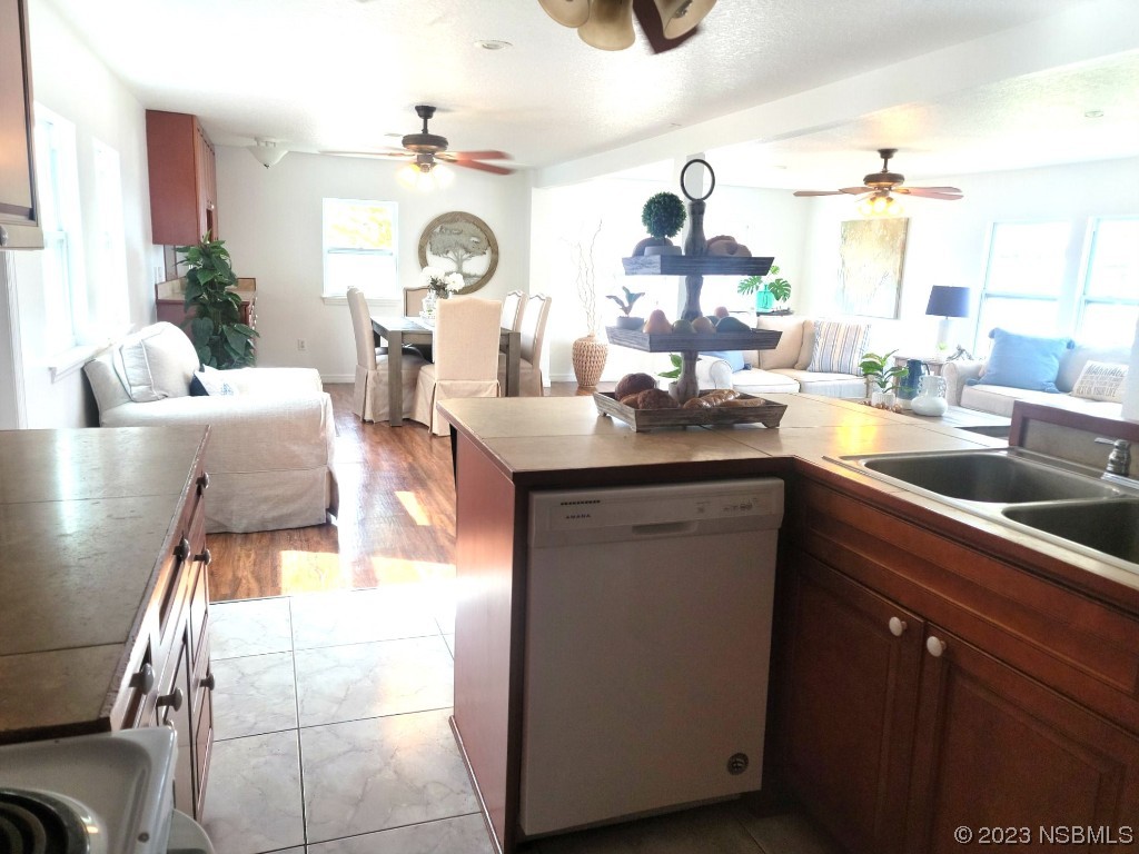 134 Douglas Street Edgewater, FL 32141 - Photo 10 of 27 a kitchen with a sink dishwasher and a clock on the wall