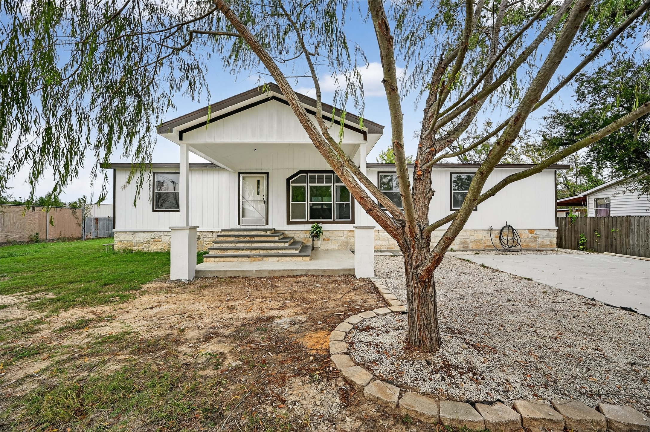 a white house that has a tree in front of the house