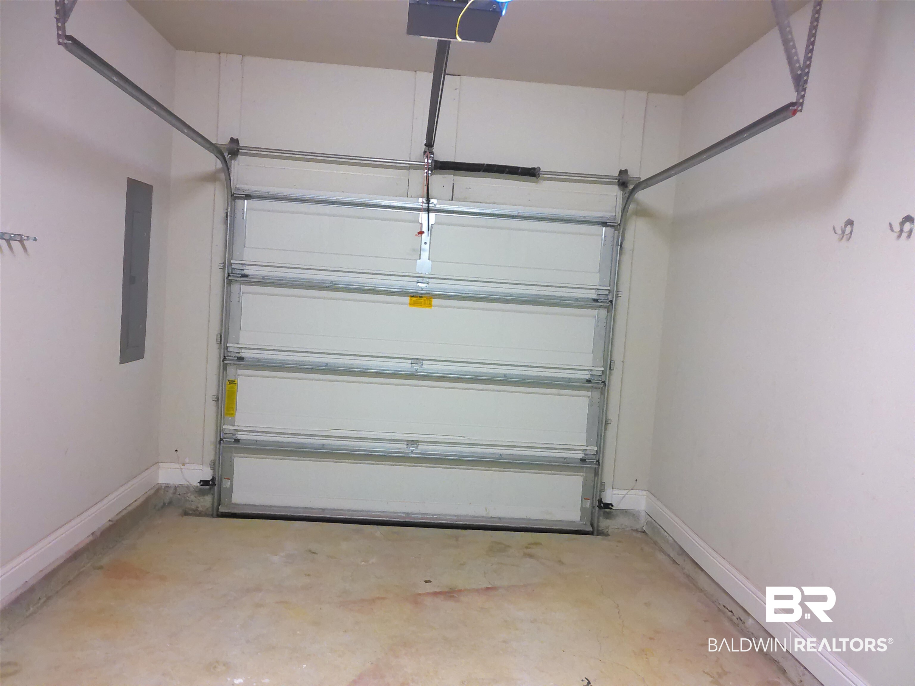 25806 Pollard Road, Unit 23 Daphne, AL 36526 - Photo 16 of 16 Garage with electric panel and a garage door opener