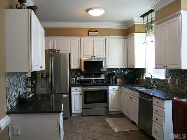 2405 Trellis Court Raleigh, NC 27616 - Photo 3 of 23 Stainless appliances, tile floor, granite countertops, tile backsplash and deep double sink create an easy-to-use kitchen with everything in easy reach.