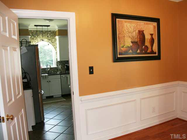 2405 Trellis Court Raleigh, NC 27616 - Photo 5 of 23 The kitchen leads past a butler's area into the bright dining room, elegant with chair rails, wall panels, a burnished hardwood floor, and fine trim details.