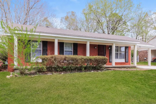front view of a brick house with a yard