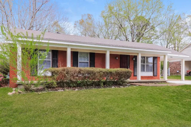 front view of a brick house with a yard