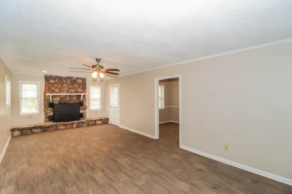 an empty room with a fireplace and chandelier
