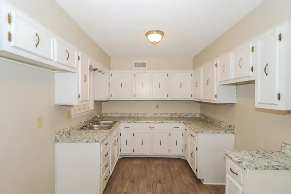a kitchen with a sink a stove and cabinets