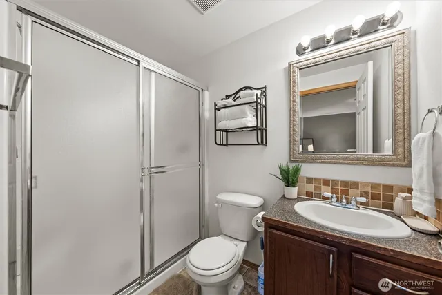 a bathroom with a granite countertop sink toilet and shower