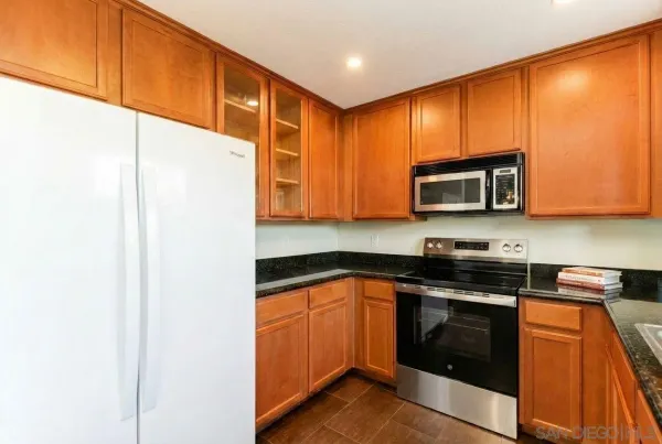 a kitchen with stainless steel appliances granite countertop white cabinets stove a sink and dishwasher