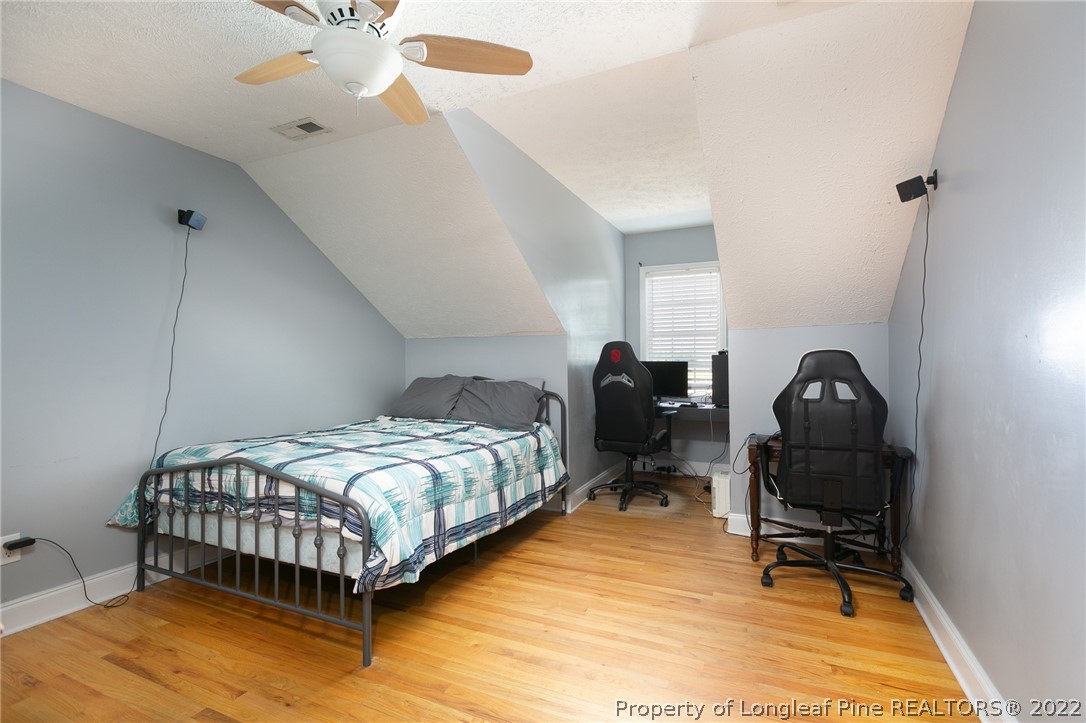 5016 J T Matthews Road Godwin, NC 28344 - Photo 25 of 50 a bedroom with a bed and a chandelier