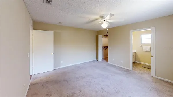 a view of a livingroom with a chandelier fan and windows