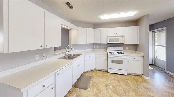 a kitchen with a sink stove and cabinets