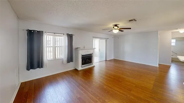 a view of a room with wooden floor and a fireplace