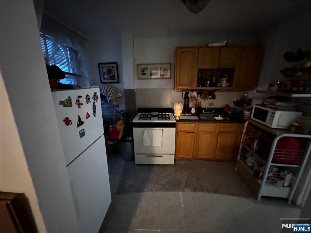 366 Summer Avenue Newark, NJ 07104 - Photo 5 of 22 a kitchen with a refrigerator a stove a microwave and cabinets