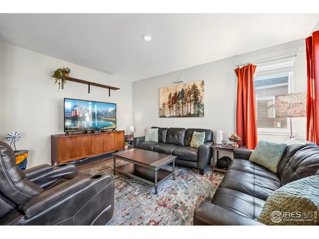 a living room with furniture a rug and a flat screen tv