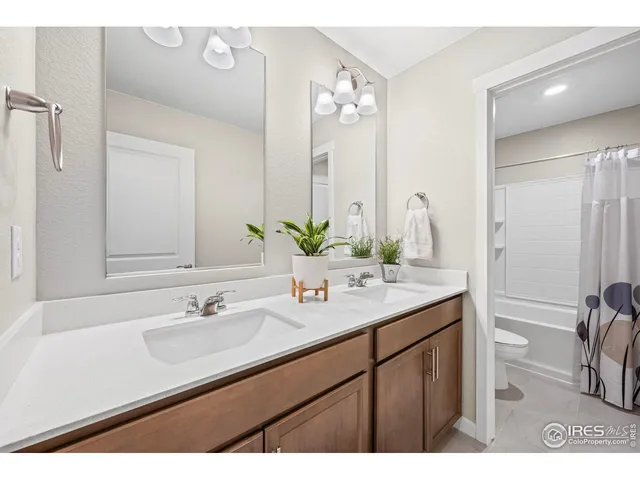 a bathroom with a sink double vanity granite and a mirror