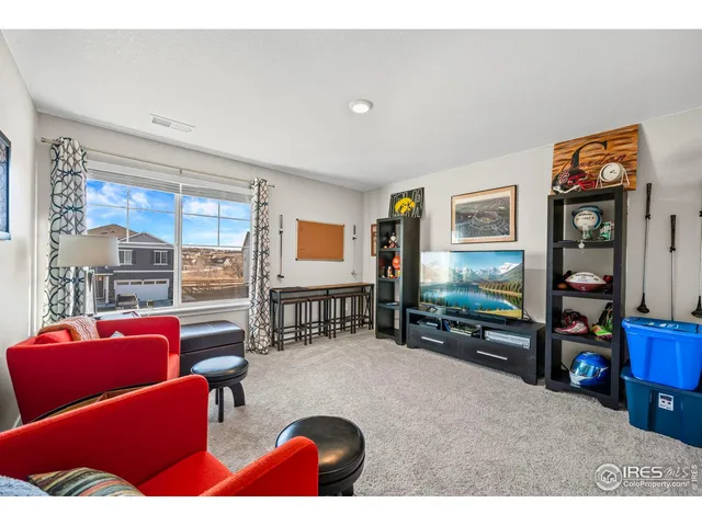 a living room with furniture a flat screen tv and next to a window