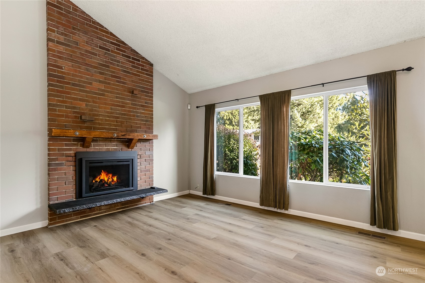 5917 Longdin Road Ferndale, WA 98248 - Photo 6 of 36 a view of an empty room with wooden floor fireplace and a window