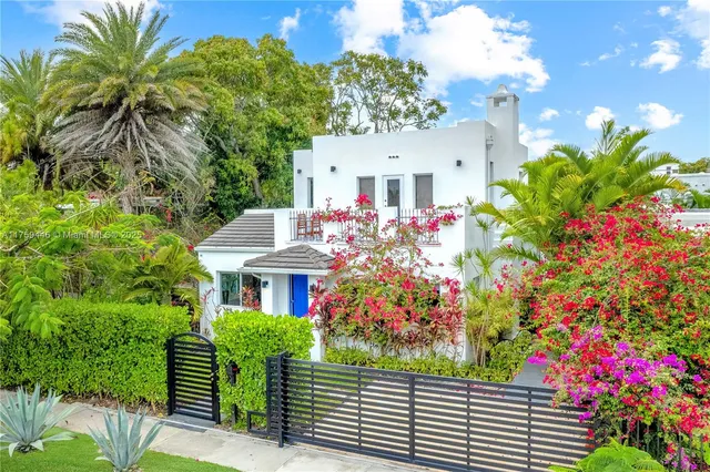 a front view of a house with a flower garden