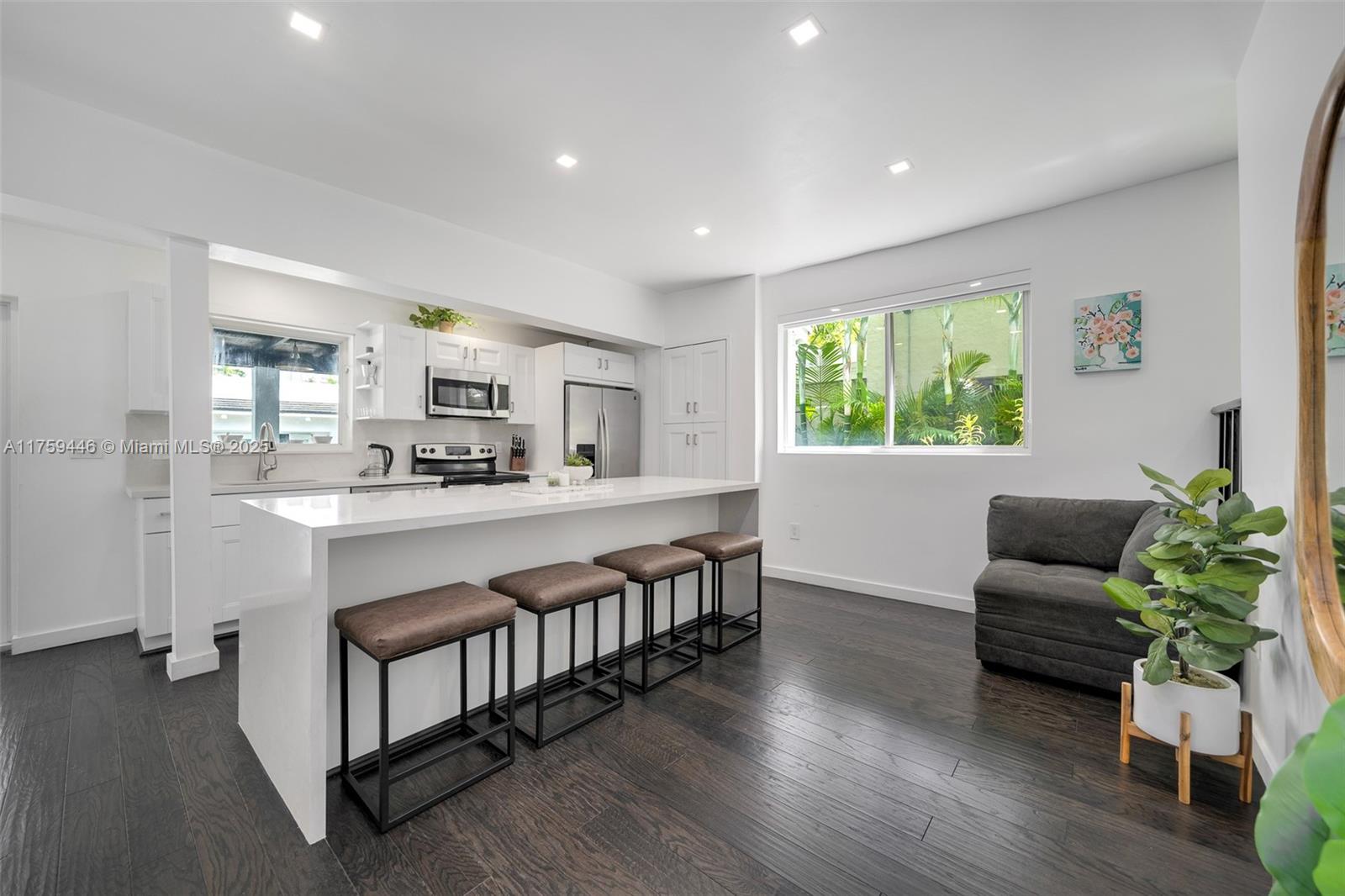 1745 Southwest 10th Street Miami, FL 33135 - Photo 12 of 51 a large living room with stainless steel appliances kitchen island granite countertop furniture a window a sink and a living room view