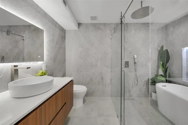a bathroom with a tub and potted plant