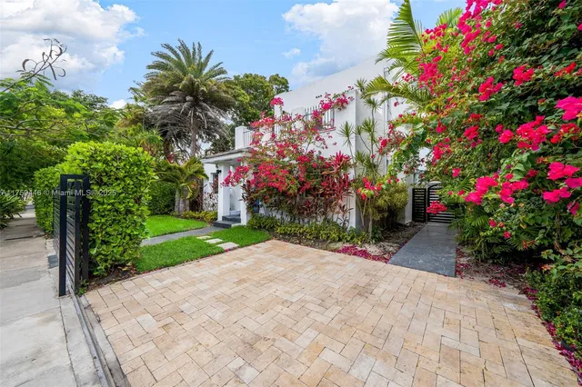 a view of a house with a yard and potted plants