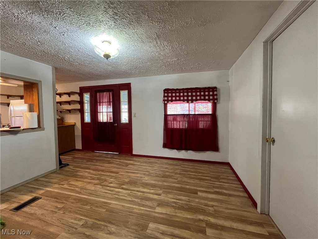 57894 Flamingo Road Senecaville, OH 43780 - Photo 8 of 20 Foyer with baseboards, wood finished floors, visible vents, and a textured ceiling