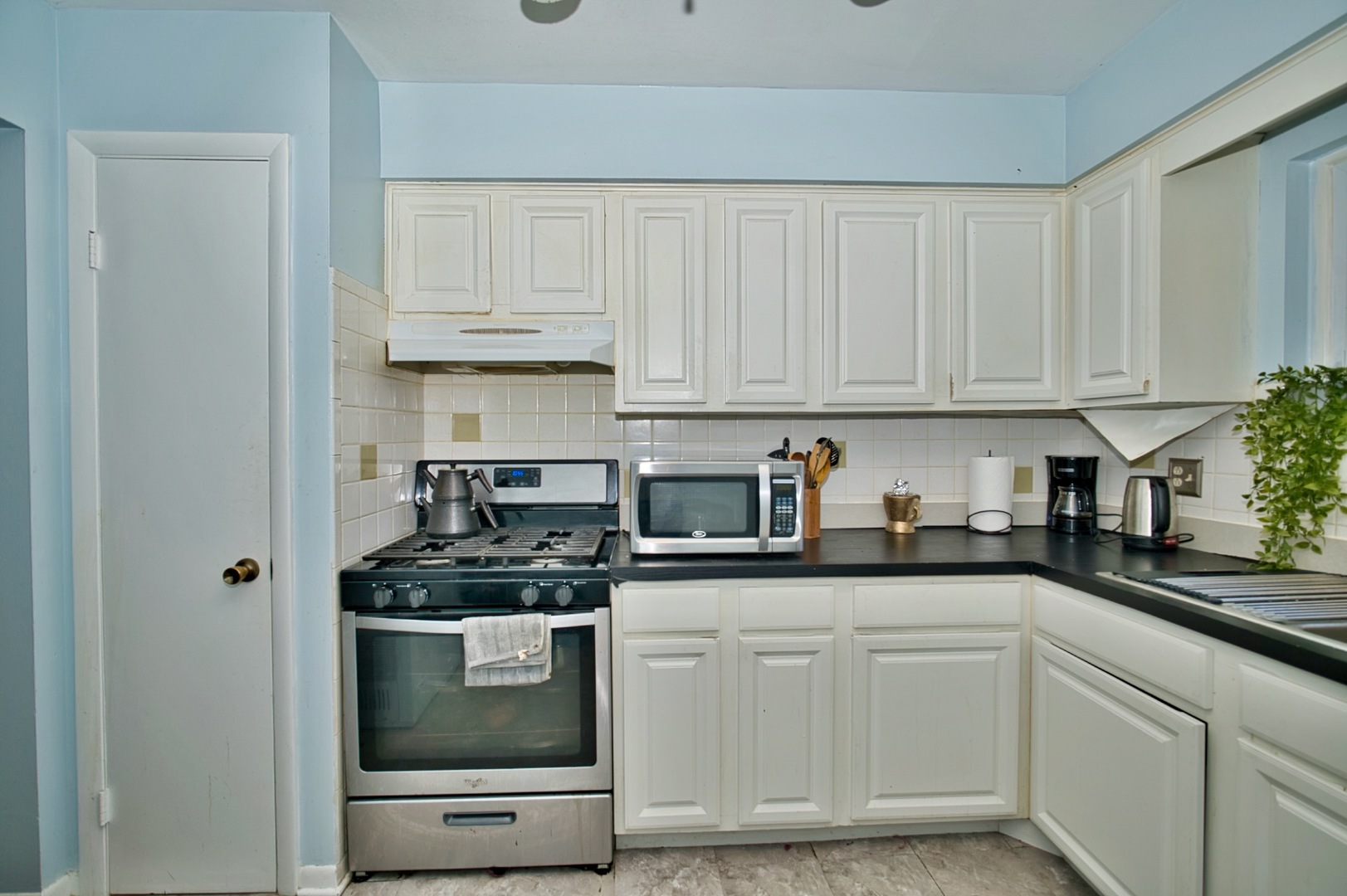 1428 West Fargo Avenue, Unit 303 Chicago, IL 60626 - Photo 19 of 28 a kitchen with granite countertop white cabinets and white stainless steel appliances