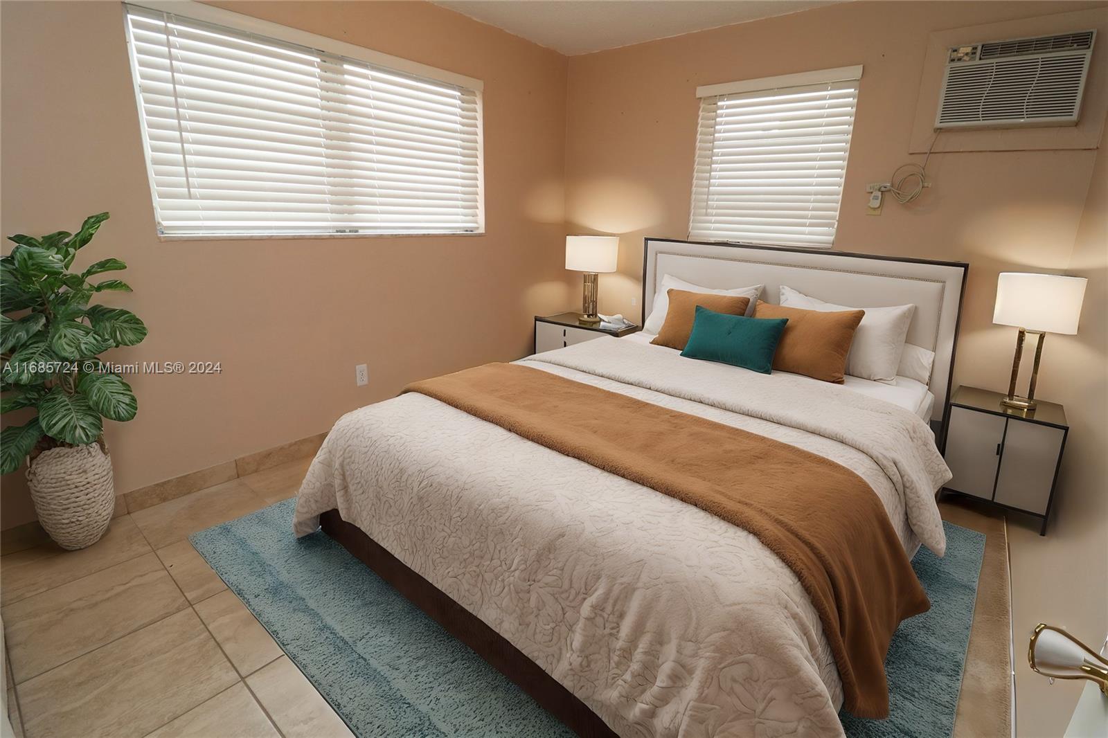 1828 Northwest 19th Street, Unit 4 Miami, FL 33125 - Photo 12 of 22 a bed sitting in a bedroom next to a window and a potted plant