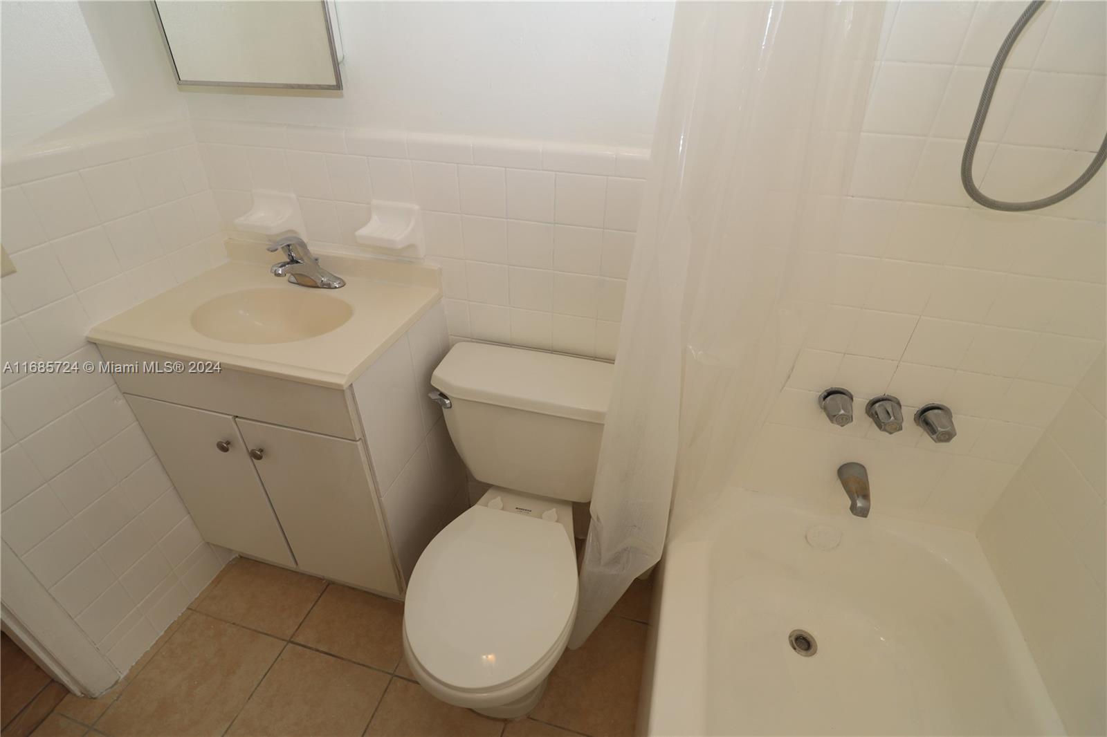 1828 Northwest 19th Street, Unit 4 Miami, FL 33125 - Photo 13 of 22 a white toilet sitting next to a bathroom sink