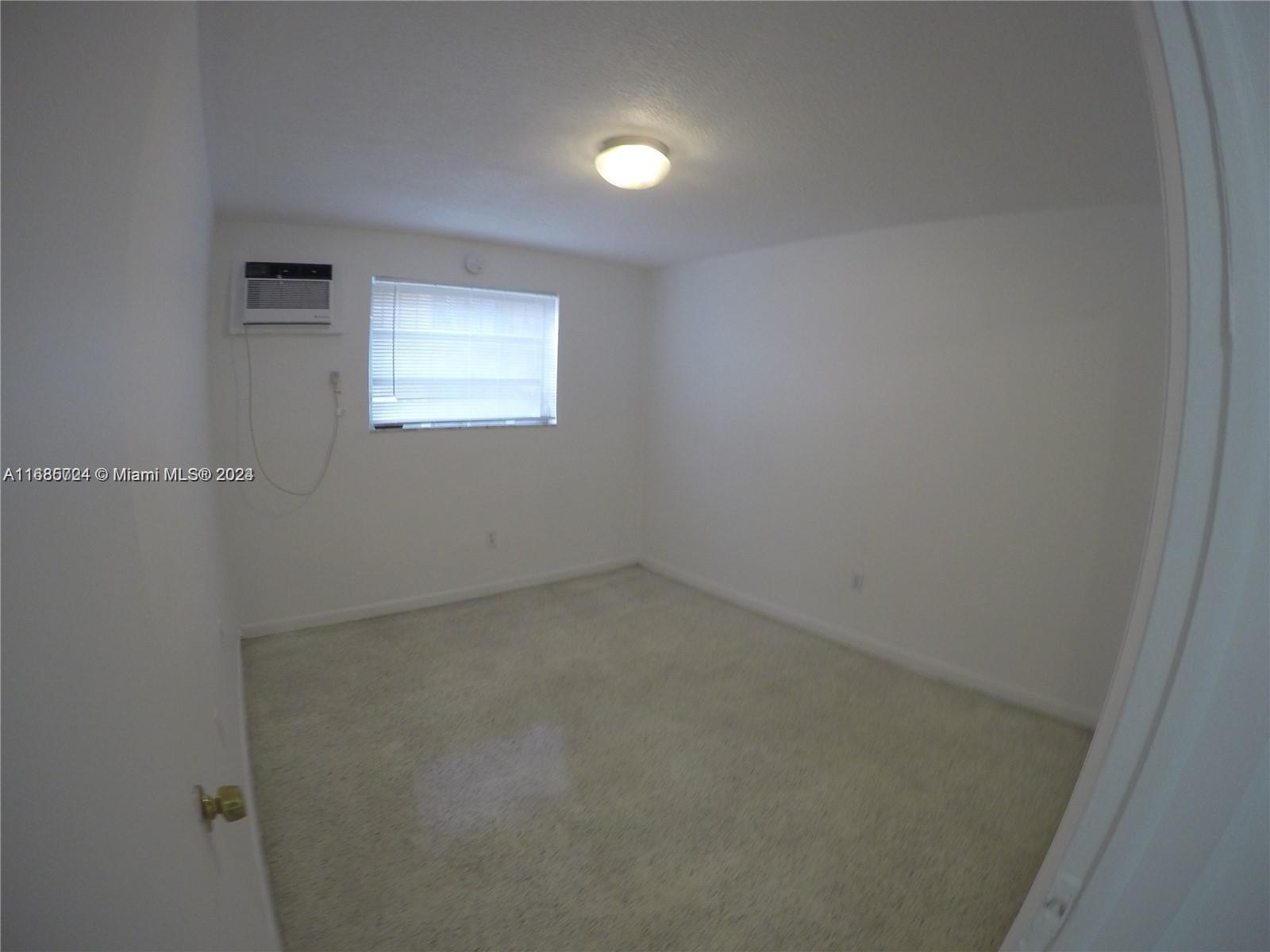 1828 Northwest 19th Street, Unit 4 Miami, FL 33125 - Photo 8 of 22 an empty room with a window