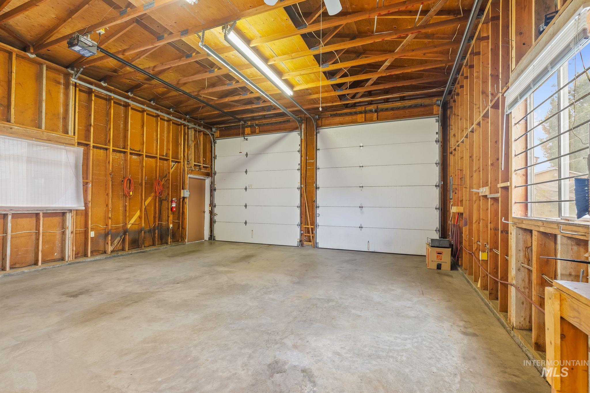 1721 3rd Street Lewiston, ID 83501 - Photo 7 of 45 Utility room featuring built-in wood shelving, a built-in wood-finish workbench, and a white ceiling-mounted fluorescent light fixture
