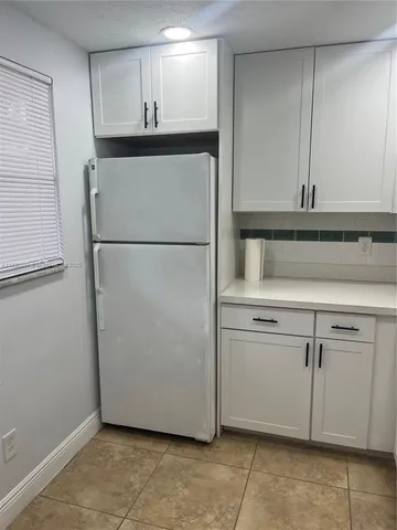 a kitchen with white cabinets and appliances