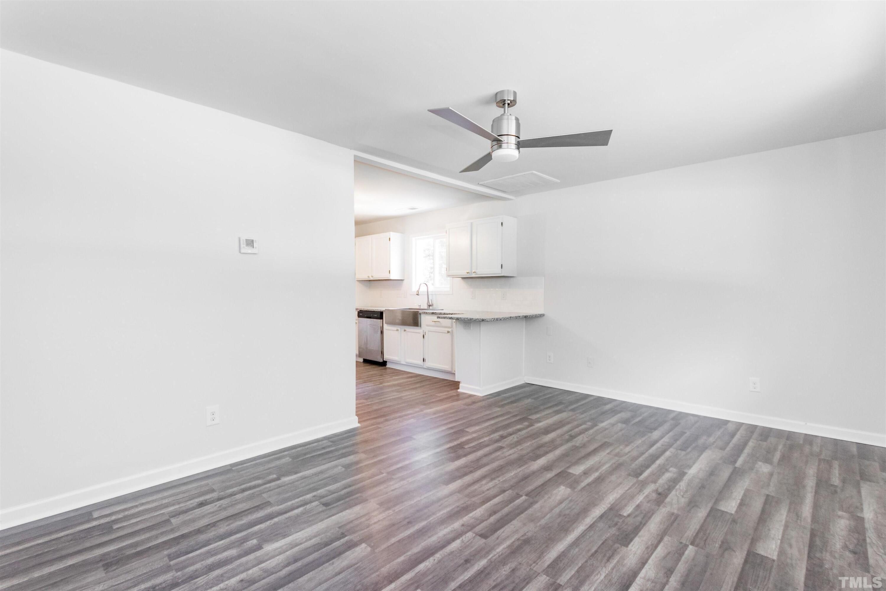708 Bailey Drive Raleigh, NC 27610 - Photo 3 of 10 a view of kitchen and empty room with wooden floor