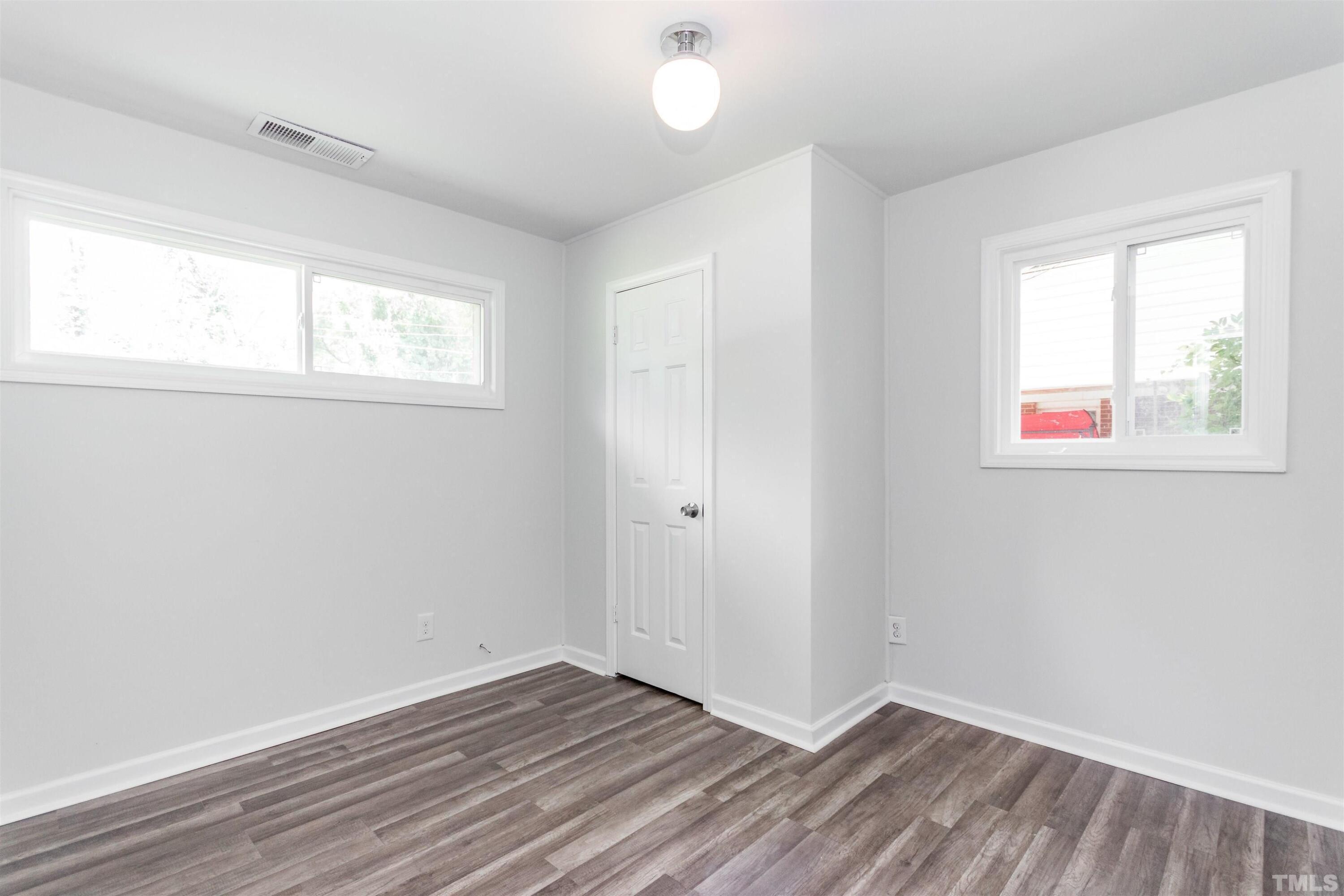 708 Bailey Drive Raleigh, NC 27610 - Photo 8 of 10 an empty room with wooden floor and windows