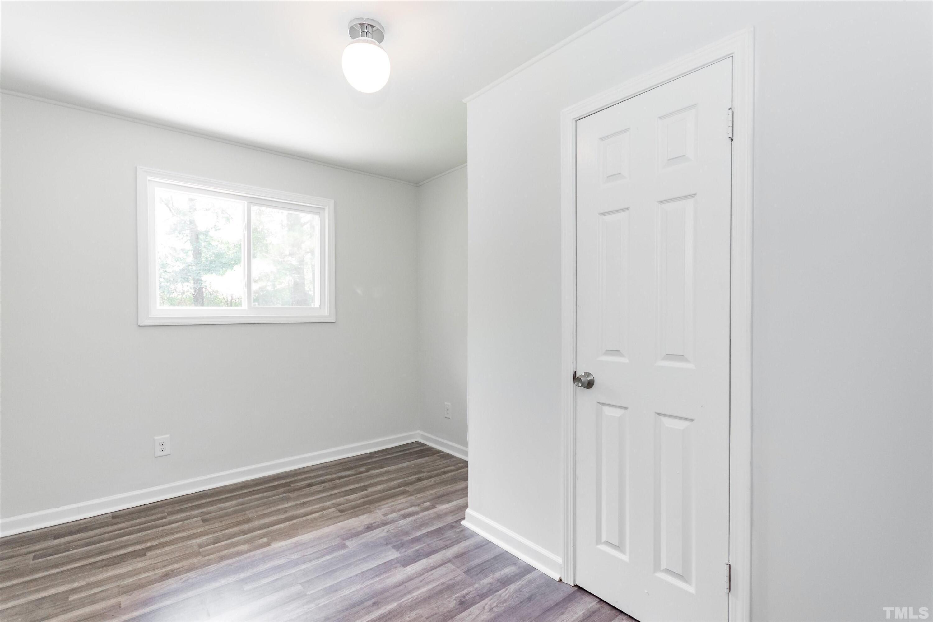 708 Bailey Drive Raleigh, NC 27610 - Photo 9 of 10 an empty room with wooden floor and windows